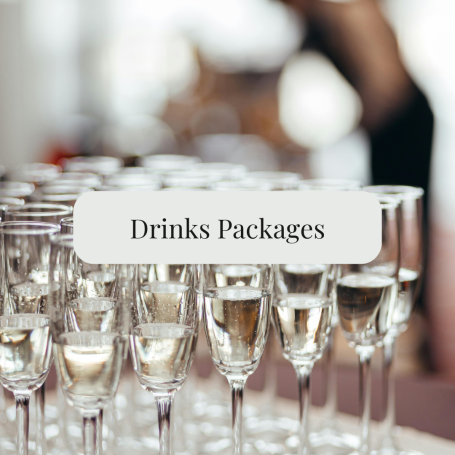 A row of champagne flutes with a sign reading "Drinks Packages."